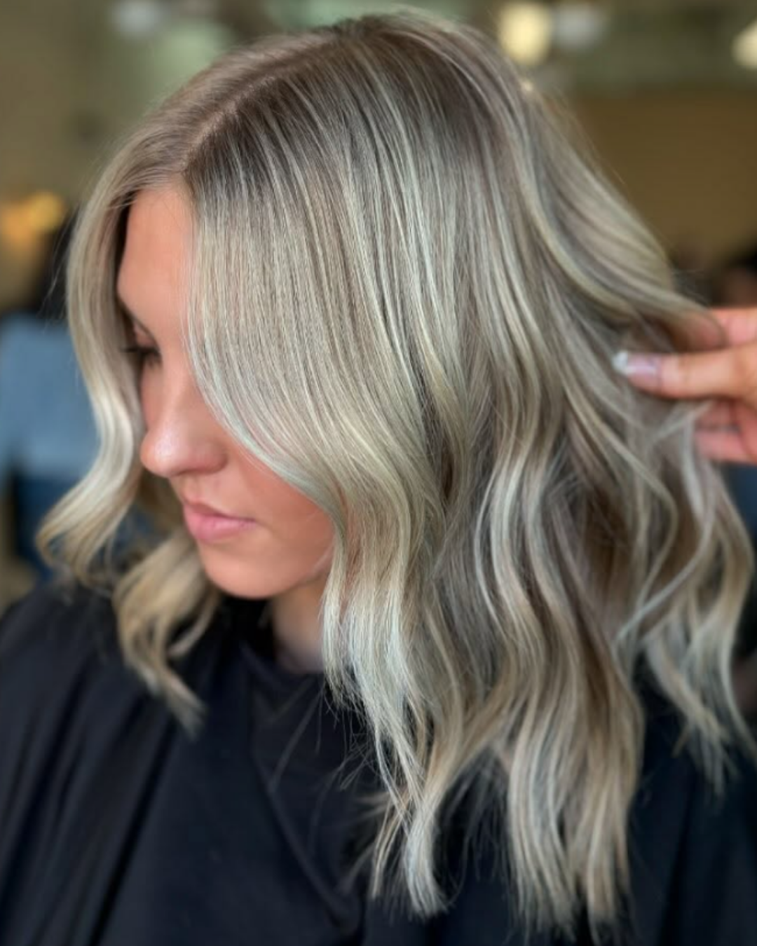 Shoulder-length wavy hair with a mix of bright blonde highlights and natural lowlights by Amelia.