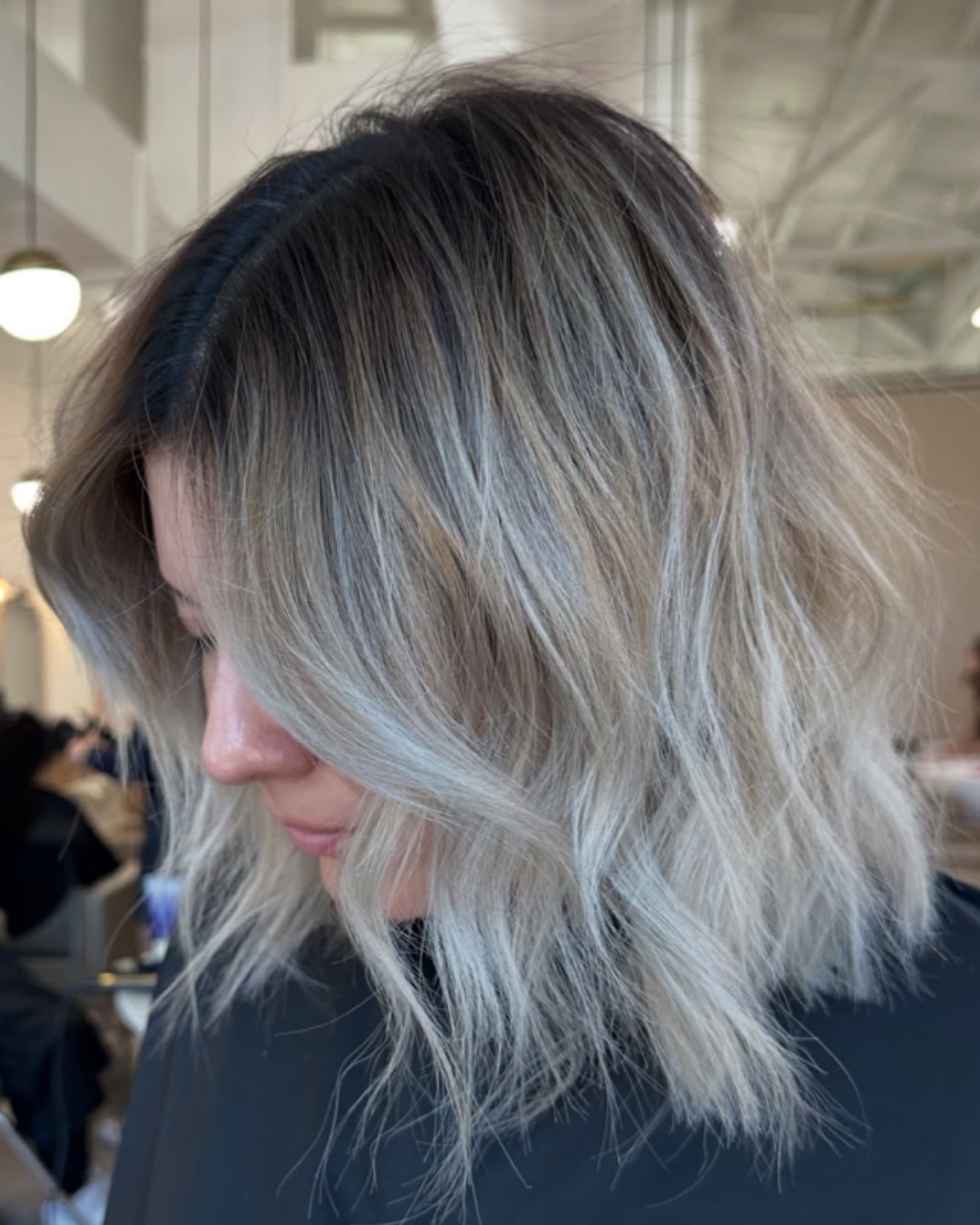 Wavy lob haircut with low-maintenance lived-in blonde balayage and dark roots by Ryan.